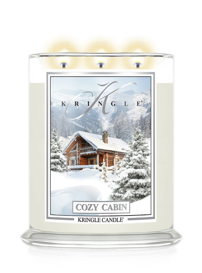 Kringle Candle with a snowy cabin design on a white background